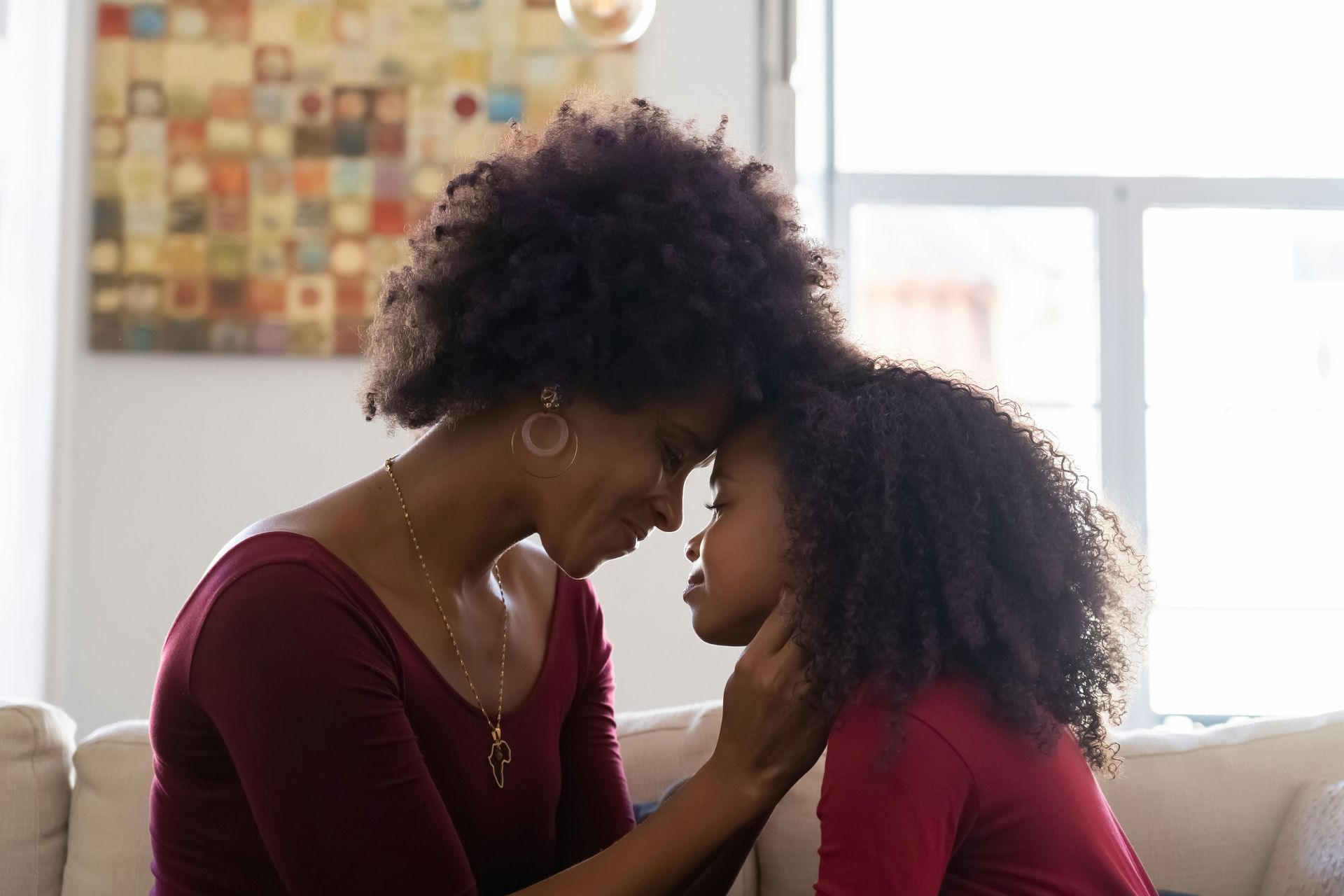 Mother and daughter, touching foreheads, symbolizing connection, care, and women’s health support