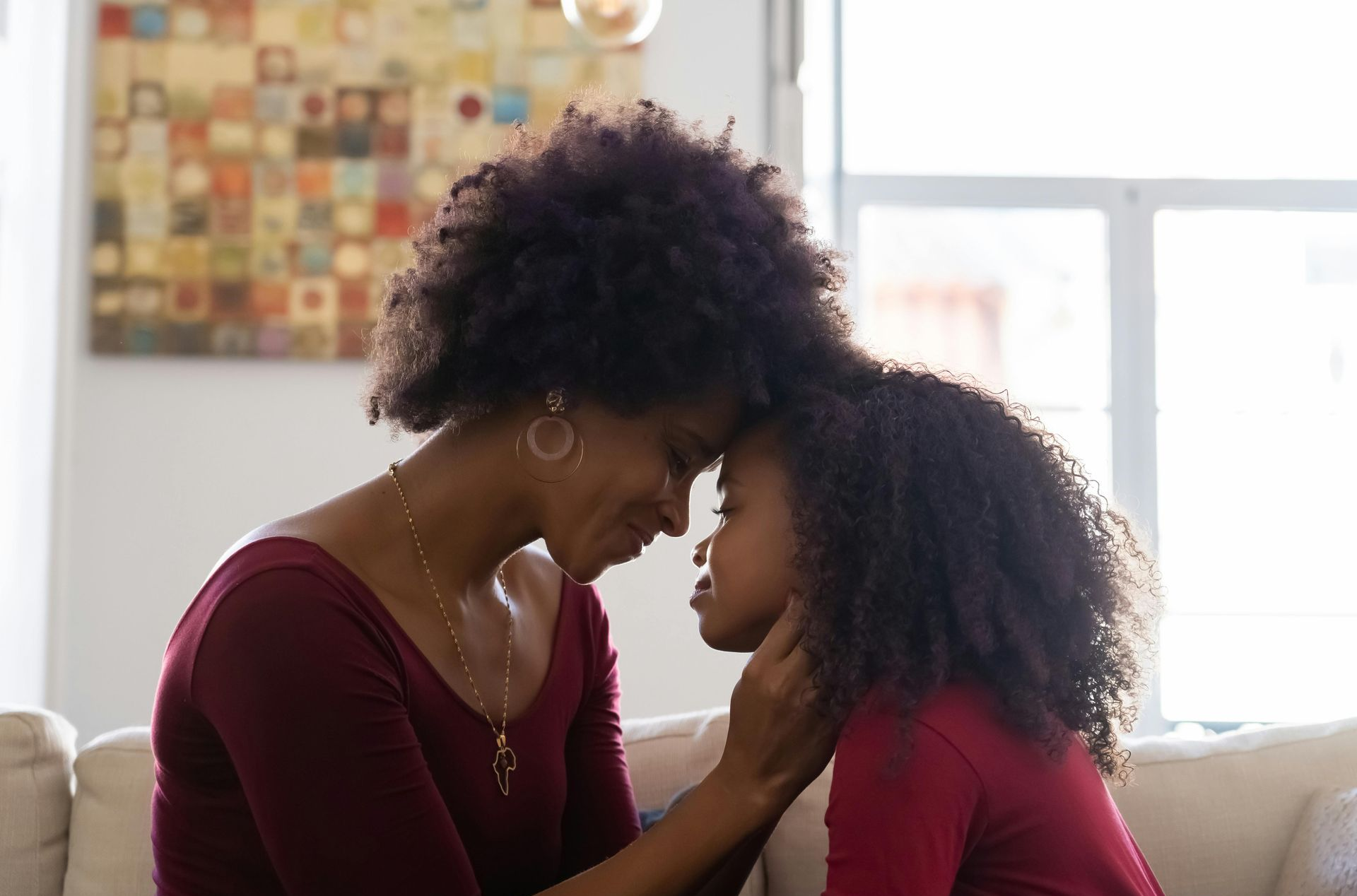 Mother and daughter, touching foreheads, symbolizing connection, care, and women’s health support.