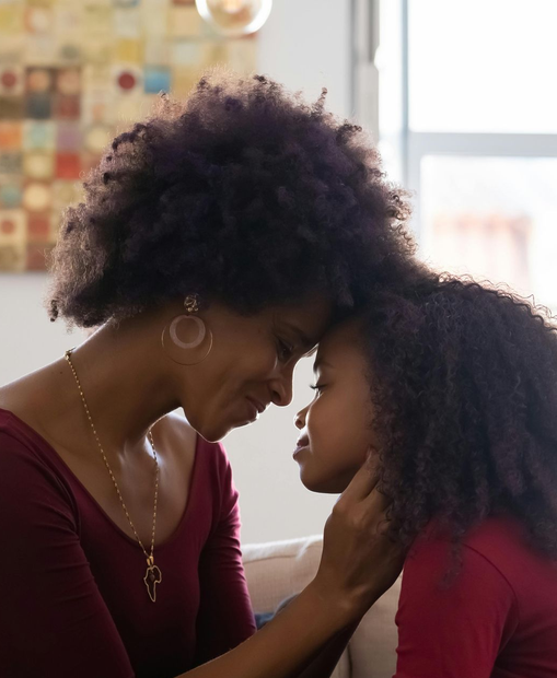 Mother and daughter, touching forehead, symbolizing connection, care, and women’s health support.