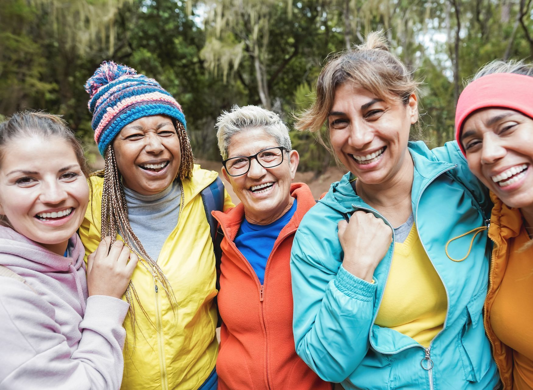 A diverse group of women, smiling together, representing community and shared women’s health experiences.