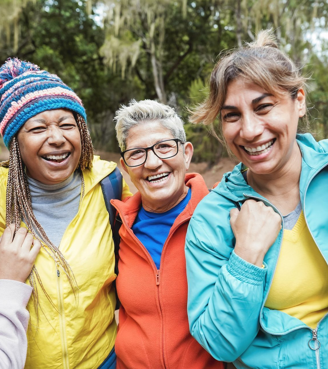 A diverse group of women, smiling together, representing community and shared women’s health experiences.