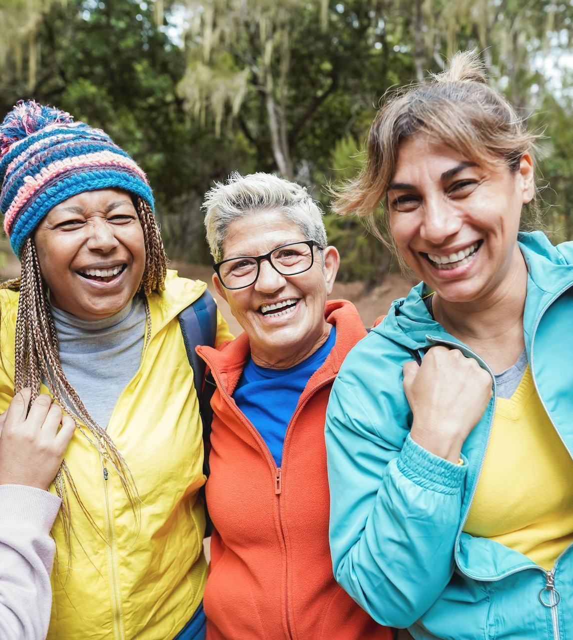 A diverse group of women, smiling together, representing community and shared women’s health experiences.