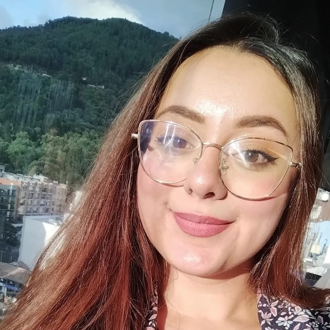 A woman wearing glasses is smiling for the camera.