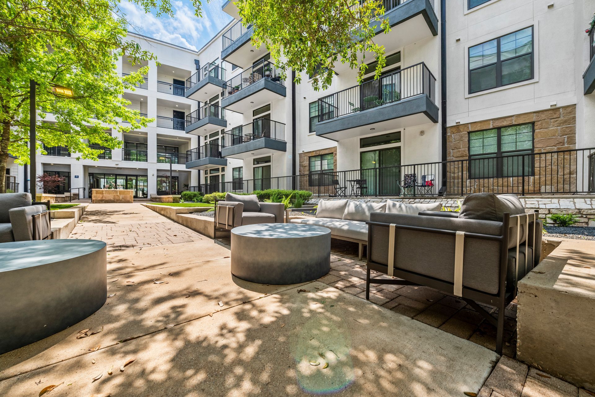 Outdoor apartment patio with seating, building in background.