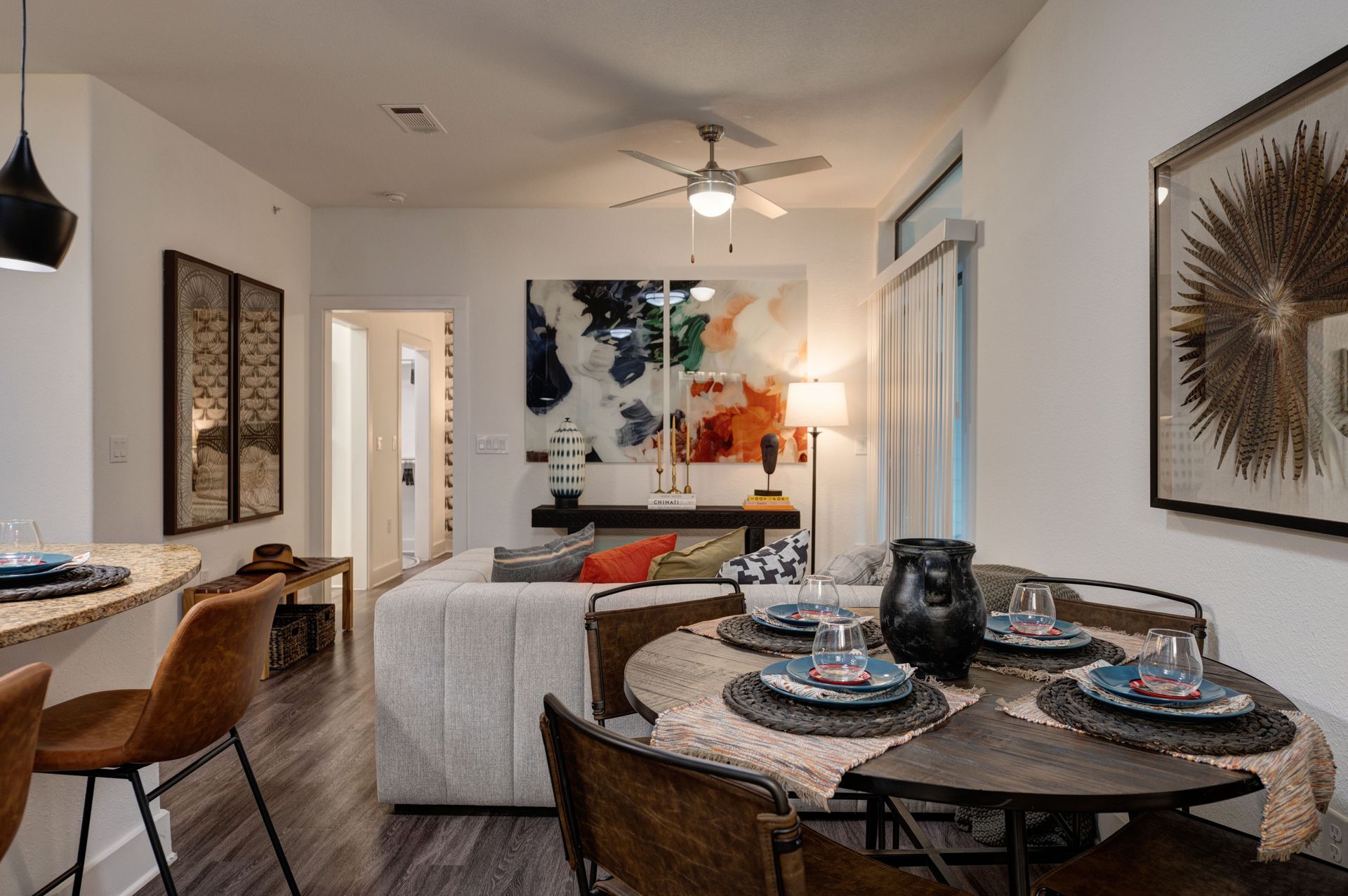 Dining area with round table, sofa, art, and breakfast bar.