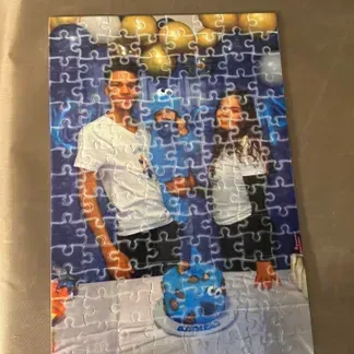 People with birthday cake puzzle. Balloon backdrop.