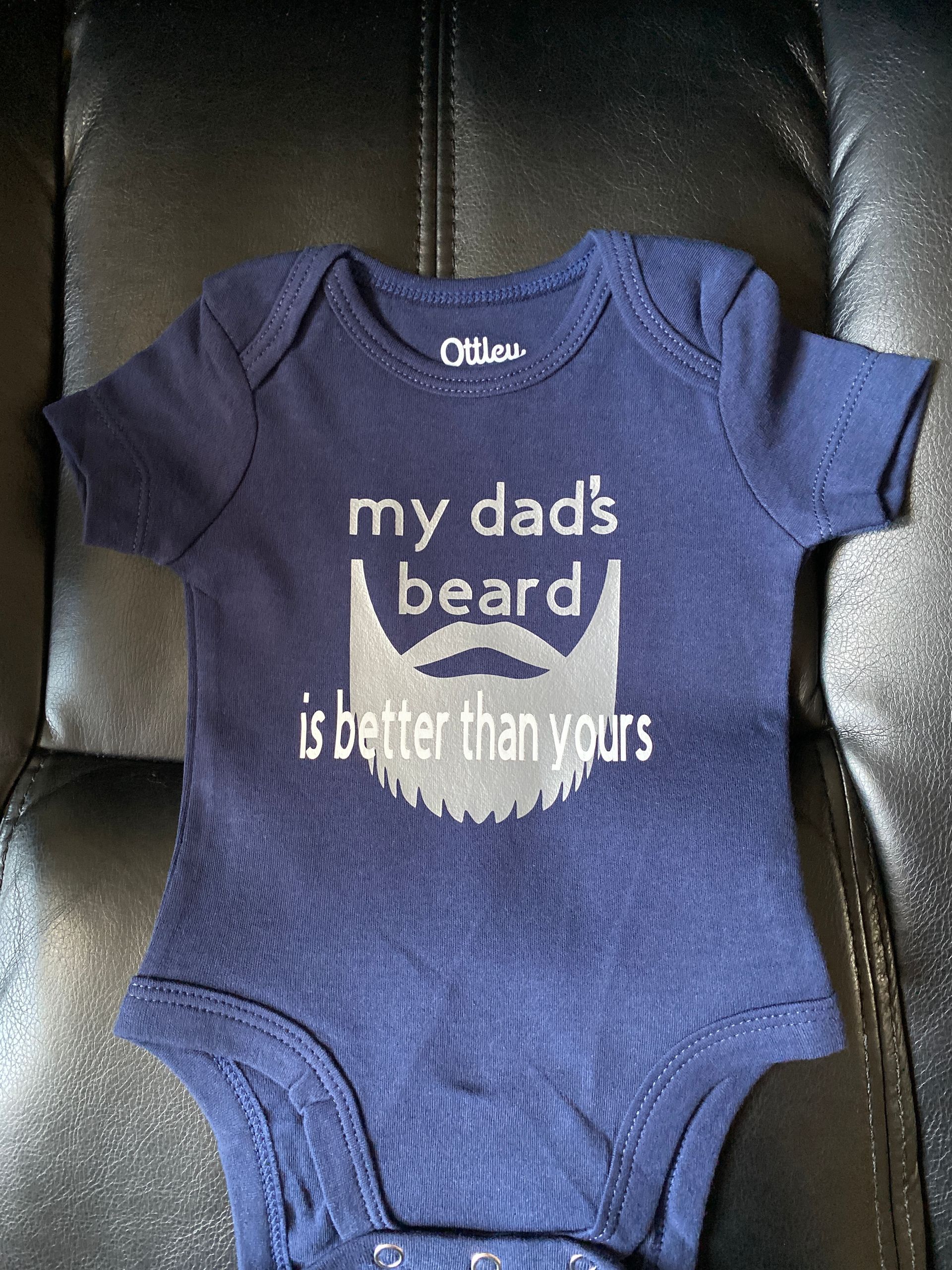 Person using a squeegee to apply rainbow-colored ink through a screen onto fabric.