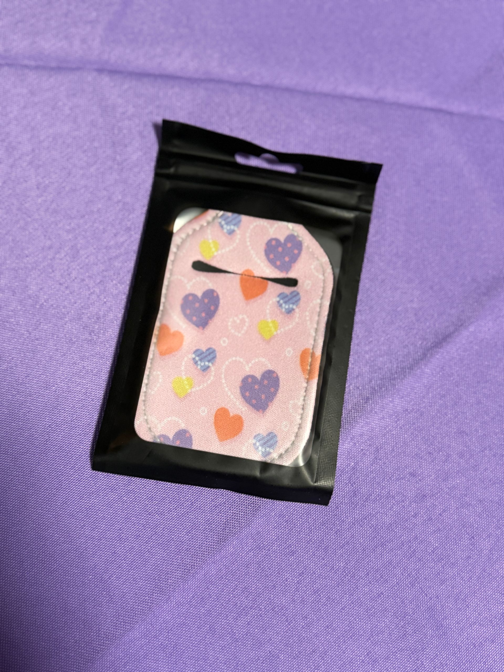 Pink blue, orange and yellow hand sanitizer keychain    with a bottle of sanitizer