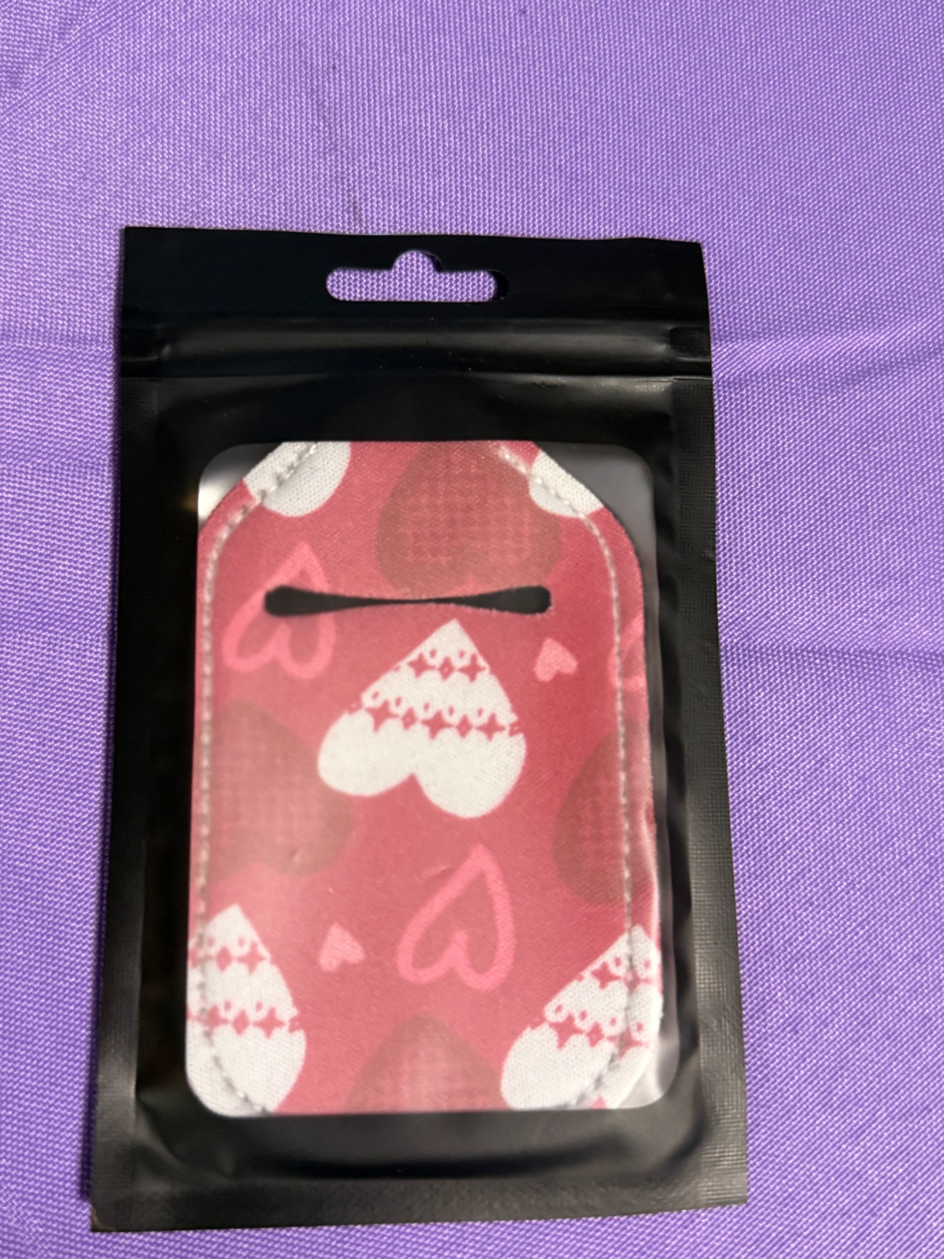 Red and white heart hand sanitizer keychain with a bottle of sanitizer