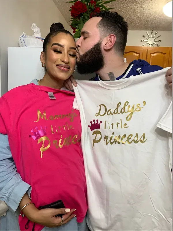 Couple holding shirts that say 