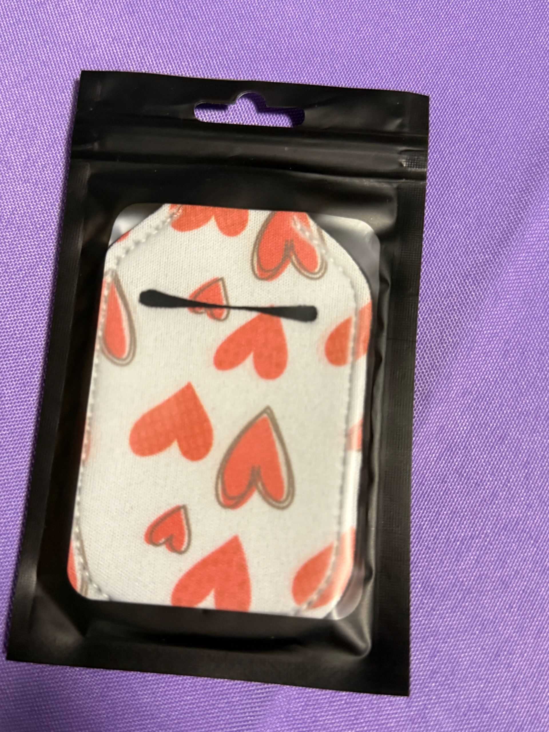 White and red heart hand sanitizer keychain with a bottle of sanitizer