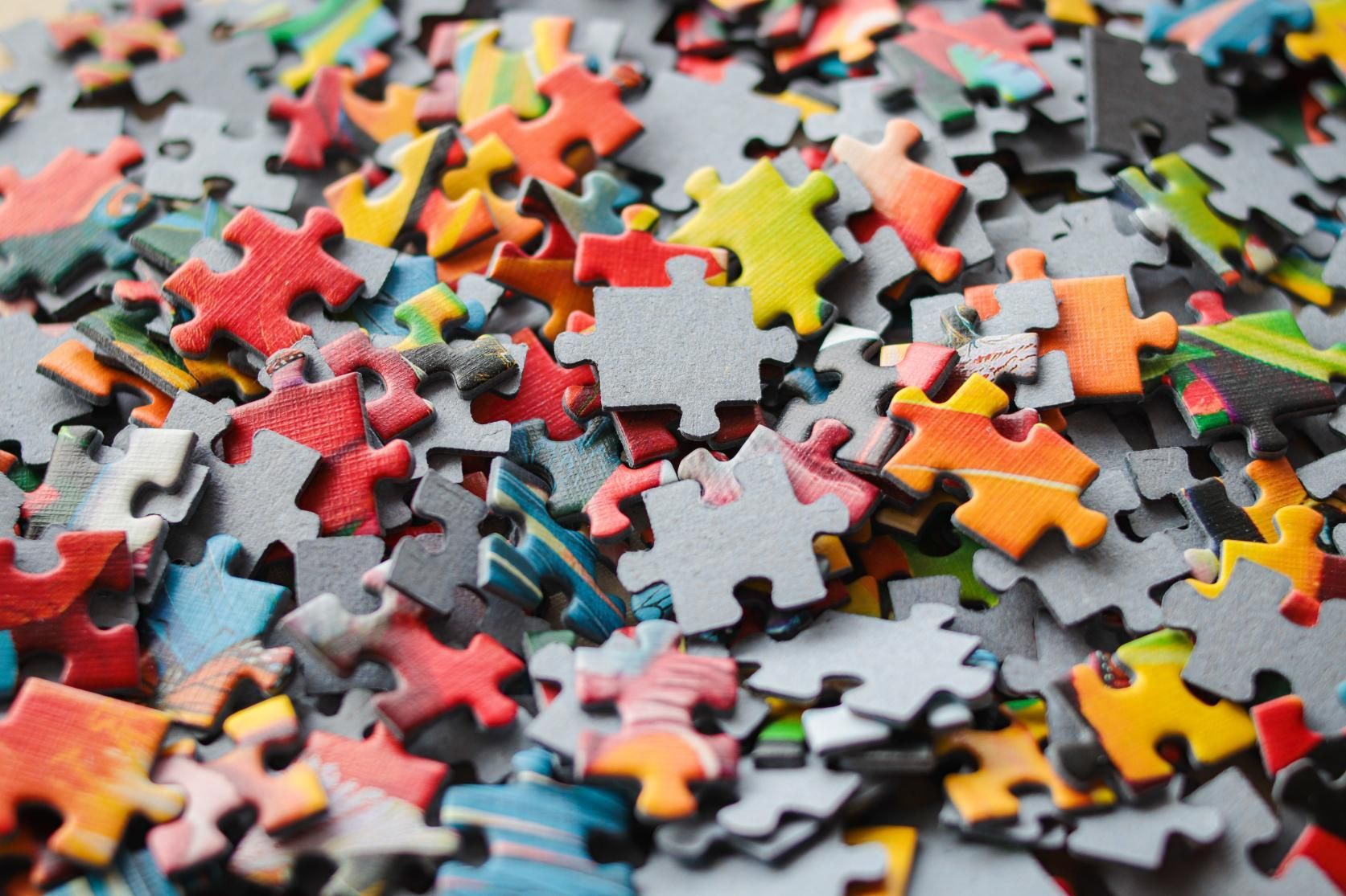Pile of multicolored jigsaw puzzle pieces.