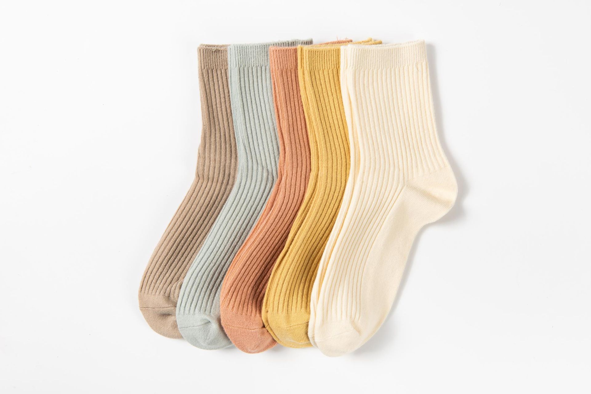 Five pastel-colored socks in a row against a white background; textures are visible.