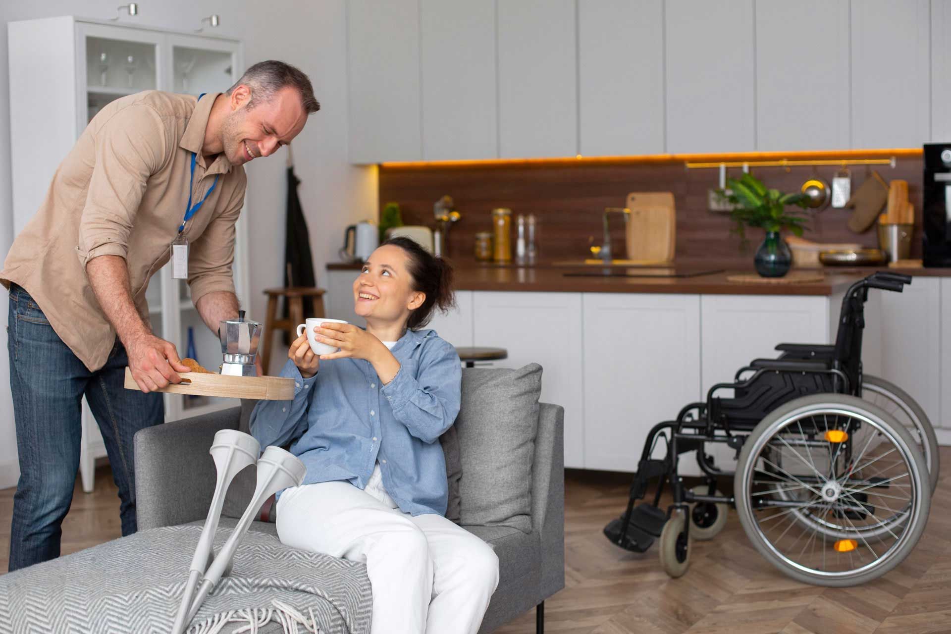 Man serves woman breakfast in living room; woman smiles, crutches near.