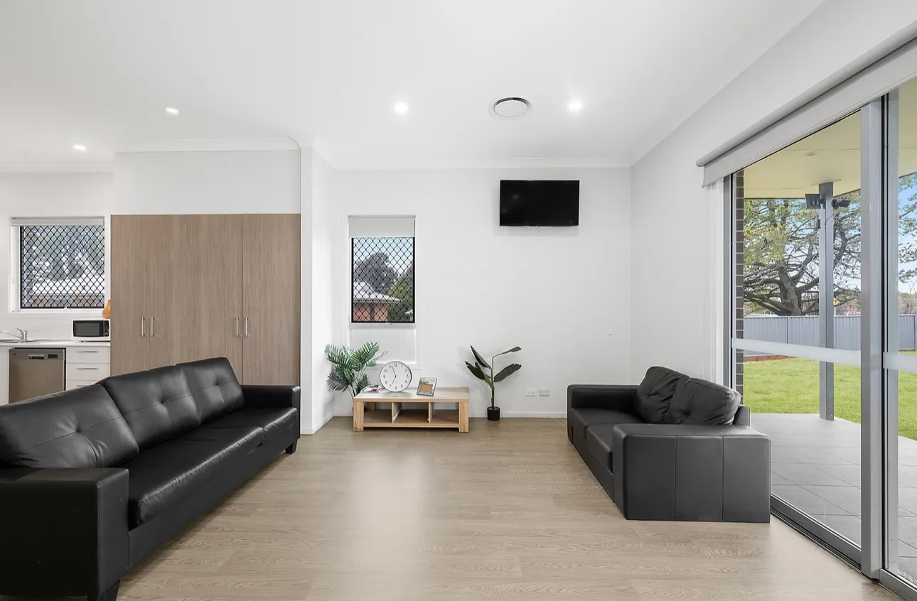 Blue tiled bathroom with shower, tub, and vanity. White floor. Blue floral wallpaper.