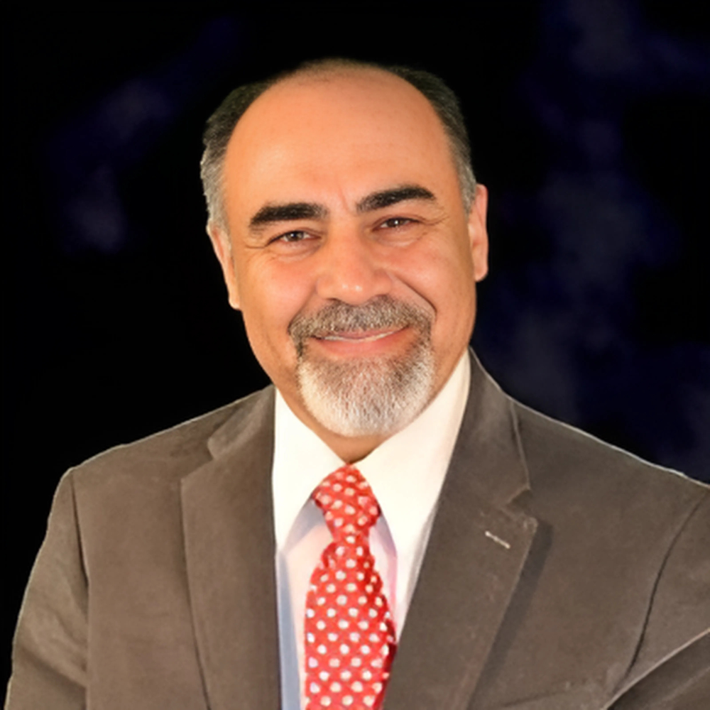 A man in a suit and tie is smiling for the camera