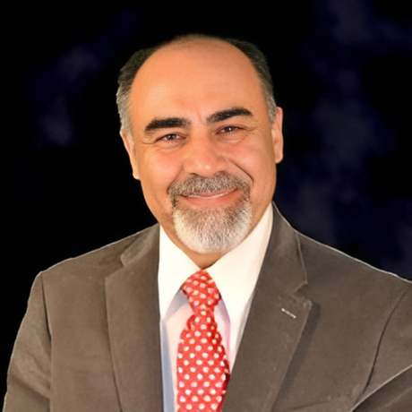 A man in a suit and tie is smiling for the camera