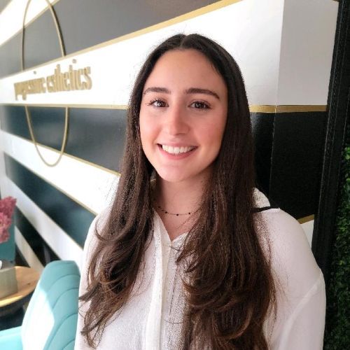 Woman smiling in front of striped wall;