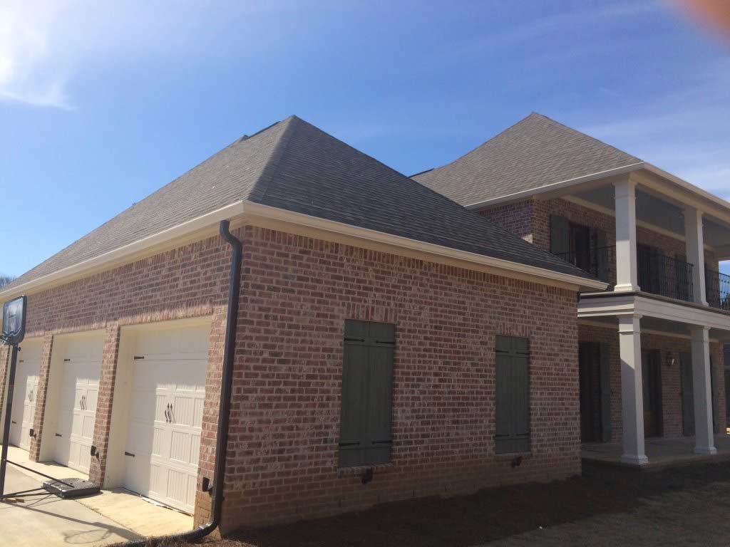 Custom Downspouts — Brick House With Three Garage Doors in Madison, MS