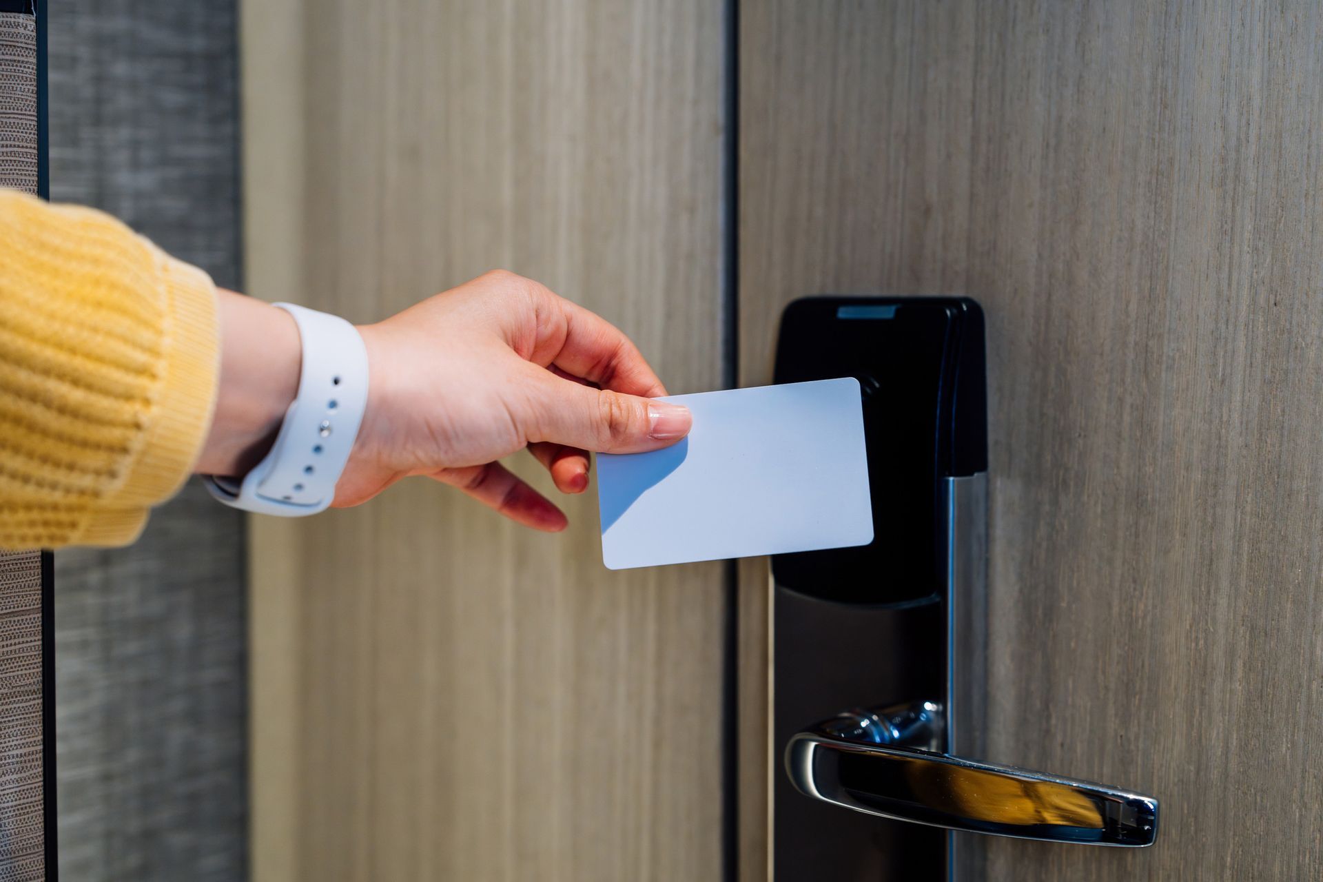 A person is inserting a card into a hotel door lock.