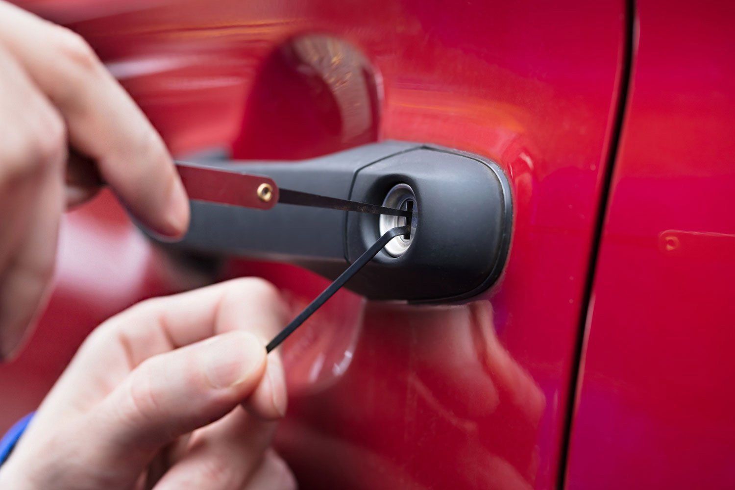 A person is using a key to open a car door.