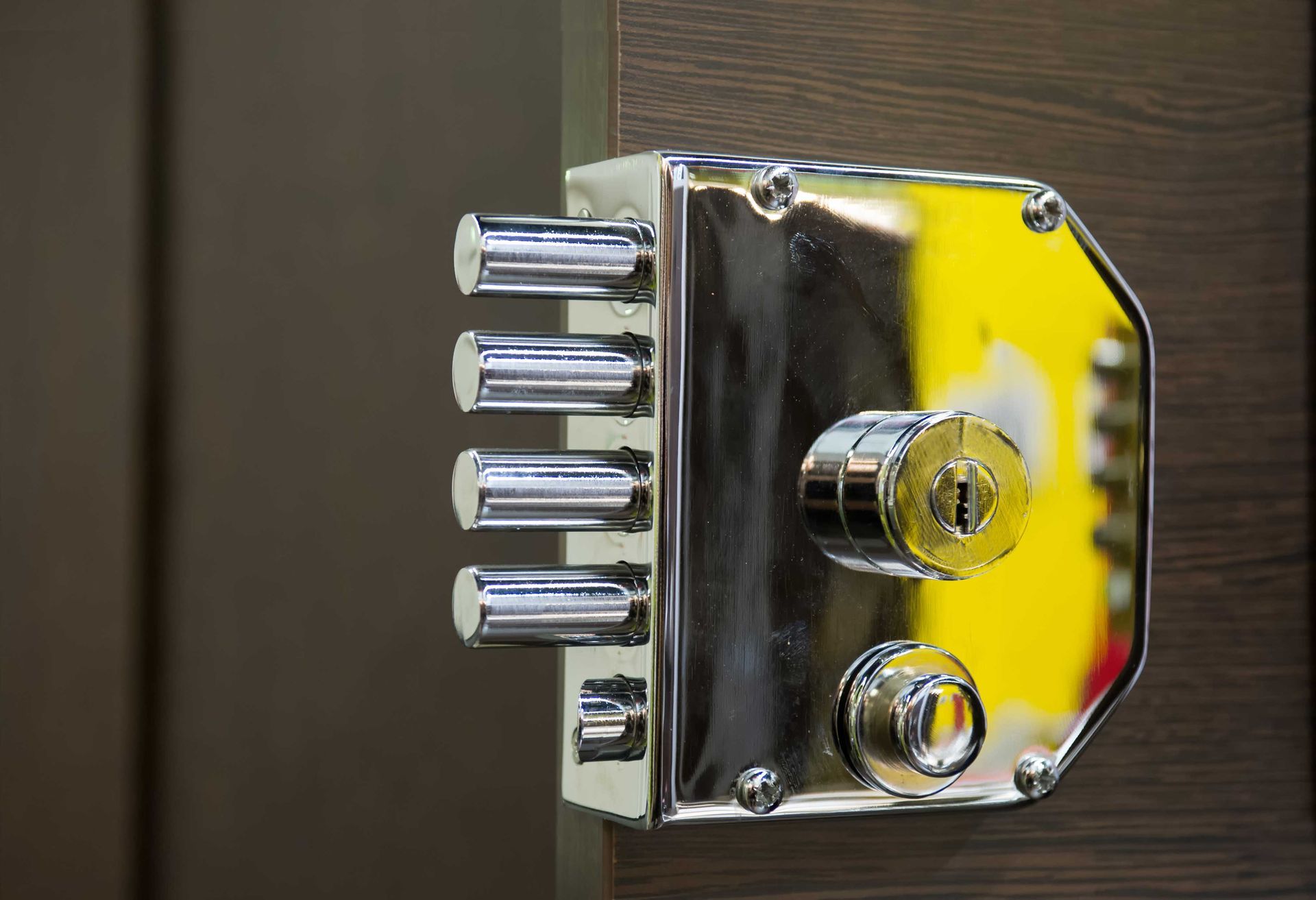 A close up of a chrome door lock on a wooden door