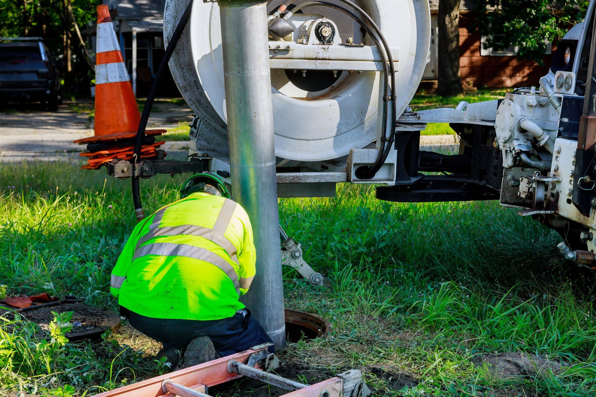 Industrial sewage cleaning truck using high-pressure water to clear blockage in a sewer line.