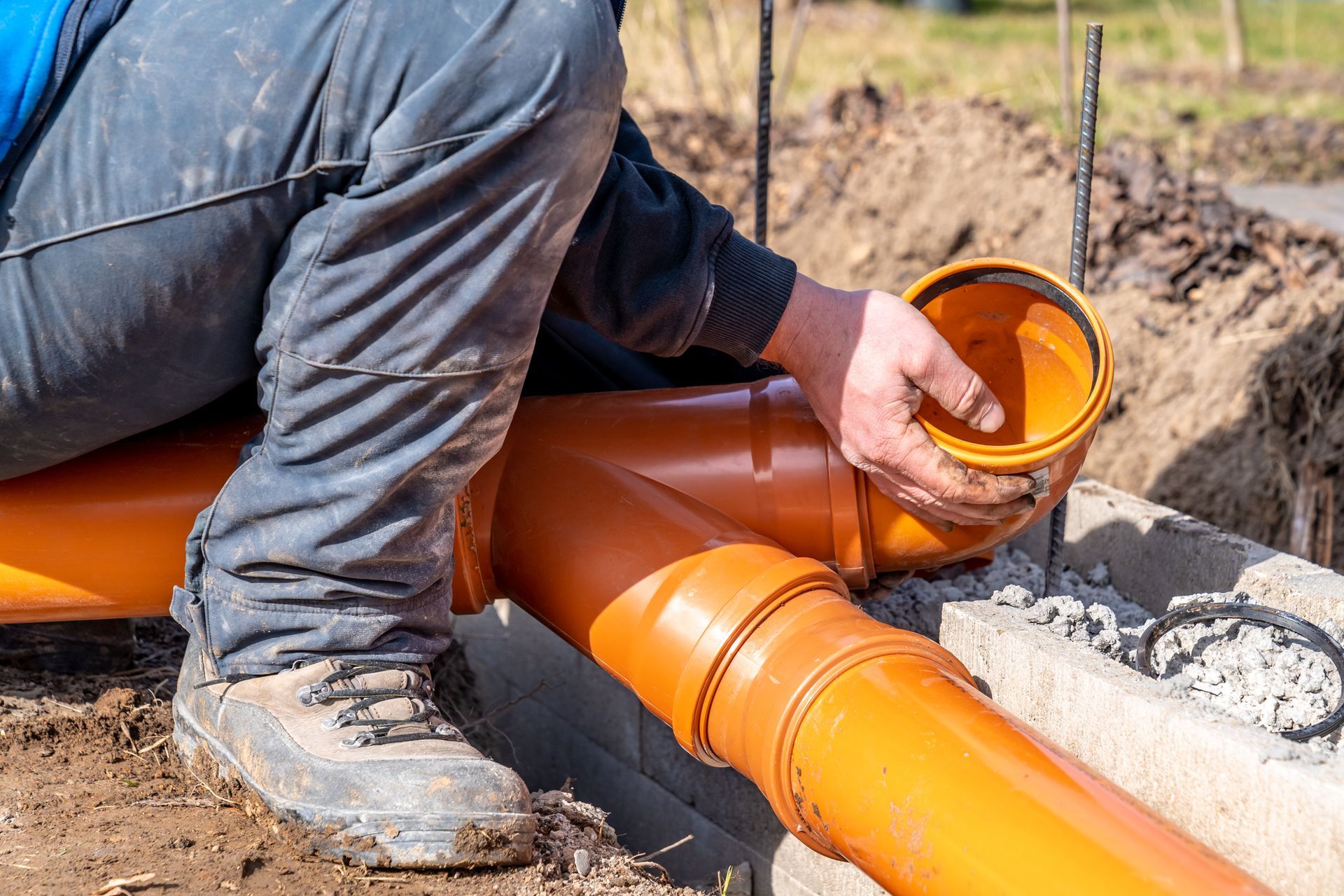 Installation of a plastic sewage pipe during house construction.