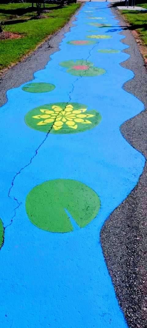 A path painted blue to resemble water with lily pads.