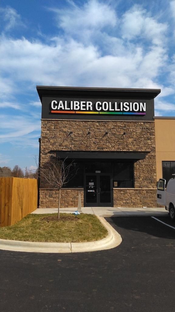 Caliber Collision building with colorful logo above a dark-framed entrance.