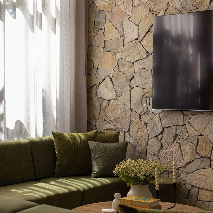 Living Room With a Stone Wall , a Couch , and a Flat Screen Tv — Beith Building & Developments Pty Ltd In Burleigh Heads, QLD