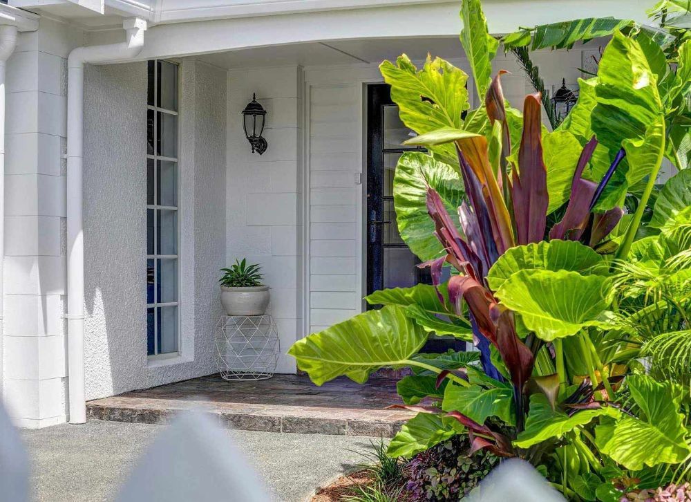 A White House with A Lush Green Garden in Front of It — Beith Building & Developments Pty Ltd In Broadbeach, QLD