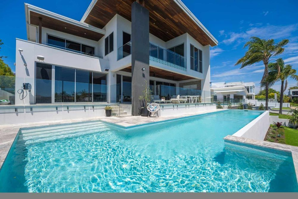 Large House With a Swimming Pool in Front of It — Beith Building & Developments Pty Ltd In Broadbeach, QLD