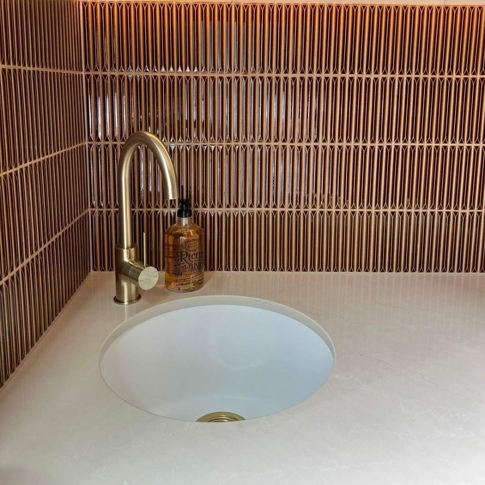 A Bathroom Sink with A Brass Faucet and A Bottle of Hand Soap — Beith Building & Developments Pty Ltd In Burleigh Heads, QLD