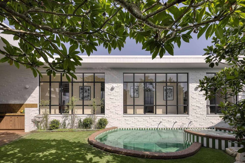 White Brick House With A Large Swimming Pool In The Backyard — Beith Building & Developments Pty Ltd In Burleigh Heads, QLD