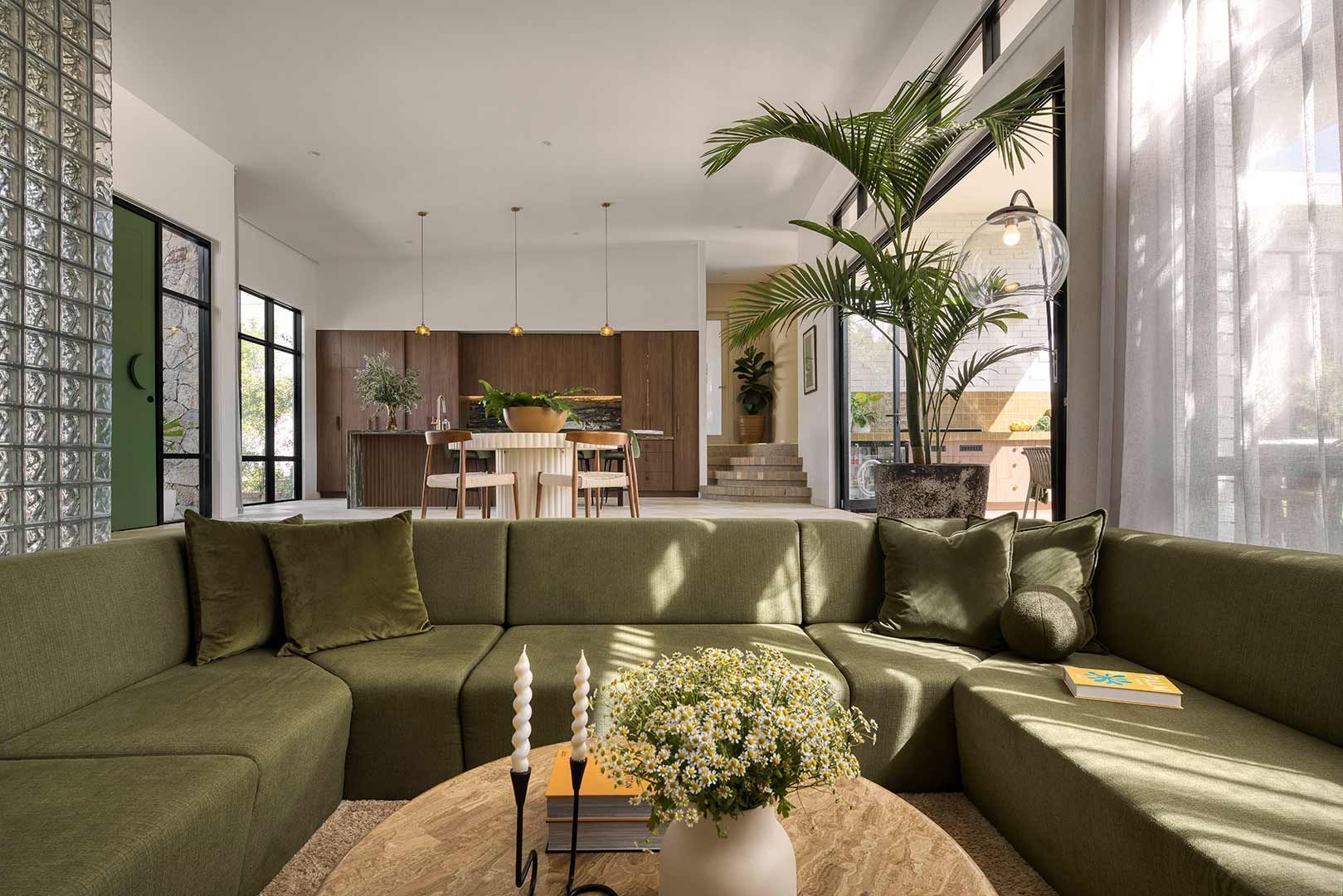 Living Room With a Green Sectional Couch and a Round Coffee Table — Beith Building & Developments Pty Ltd In Burleigh Heads, QLD