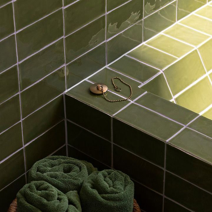 Basket of Green Towels Sits Next to a Bathtub — Beith Building & Developments Pty Ltd In Burleigh Heads, QLD