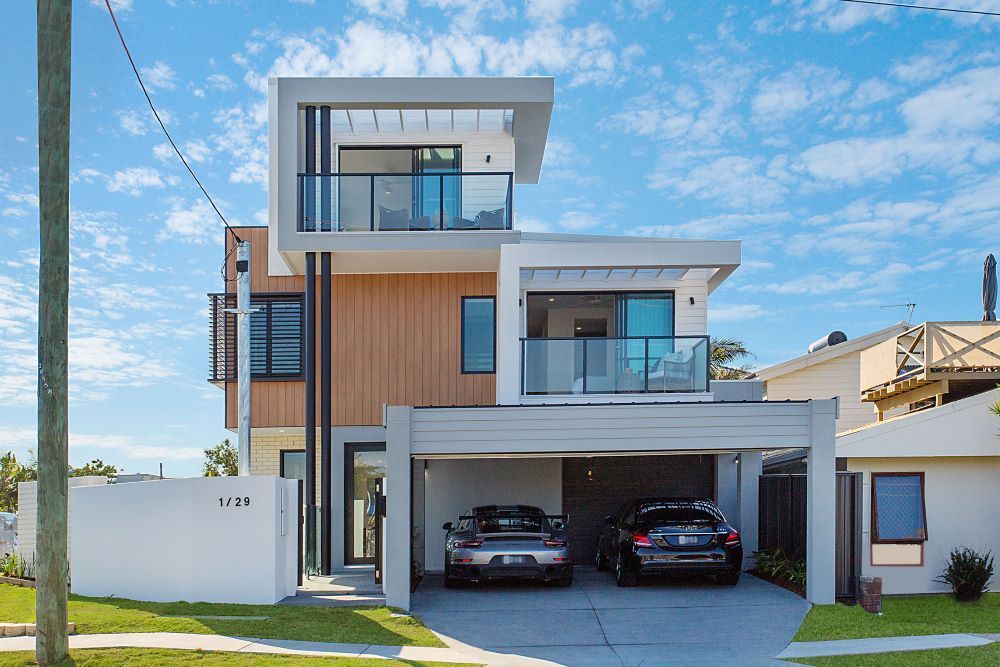 A Modern House With Two Cars Parked in Front of It — Beith Building & Developments Pty Ltd In Burleigh Heads, QLD