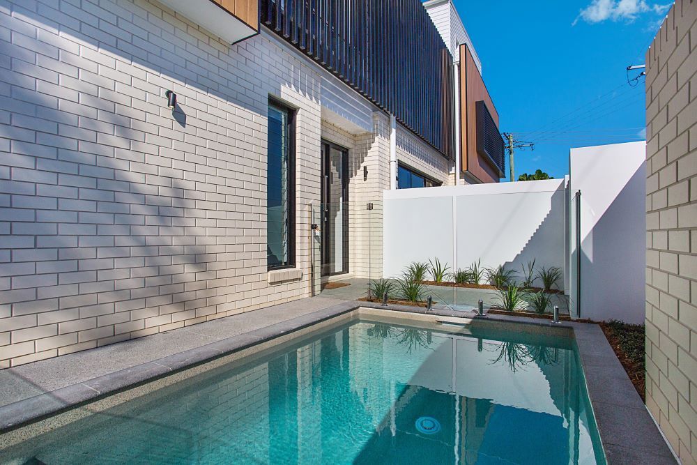 There is a large swimming pool in the backyard of a house. — Beith Building & Developments Pty Ltd In Burleigh Heads, QLD
