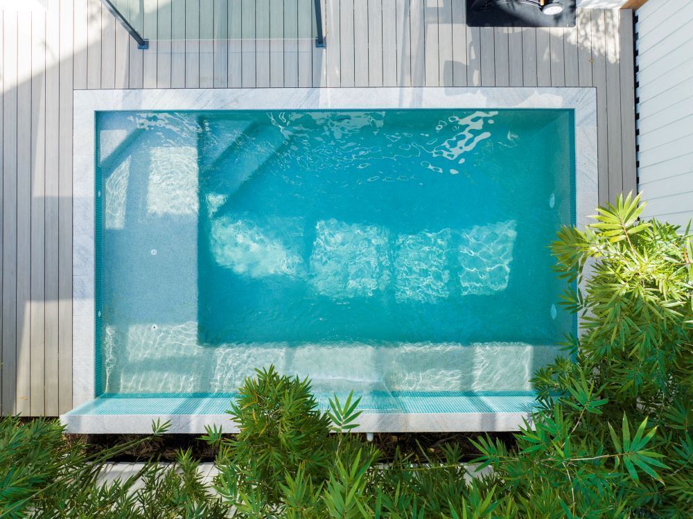 An Aerial View of a Swimming Pool Surrounded by Trees and a Wooden Deck — Beith Building & Developments Pty Ltd In Burleigh Heads, QLD