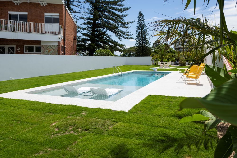 A large swimming pool in the backyard of a house