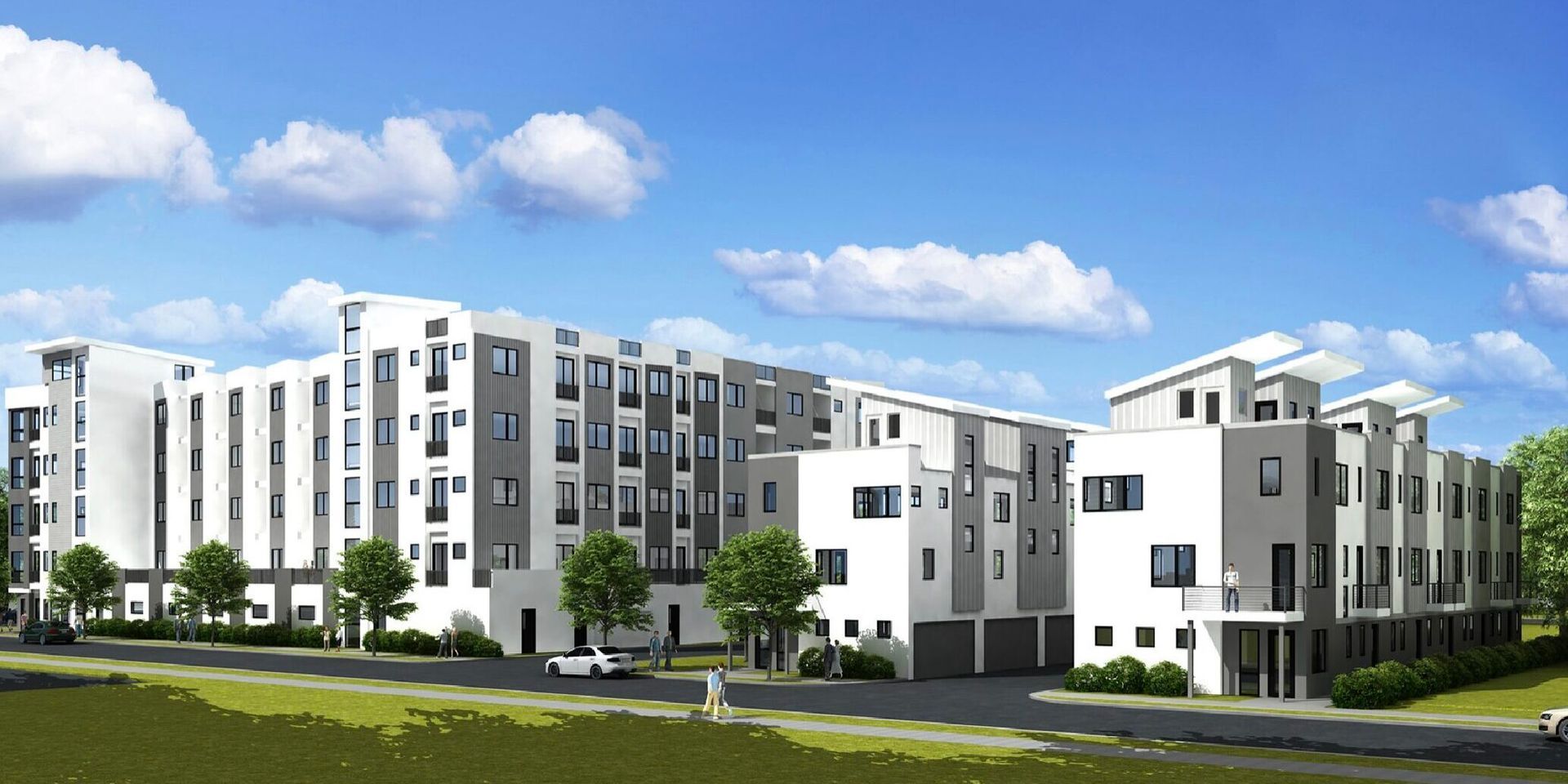 Modern multi-story apartment building with white and gray exterior, blue sky, and green landscaping.