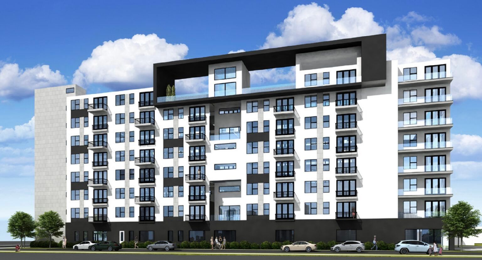 Modern white and black apartment building with balconies, under a partly cloudy sky.