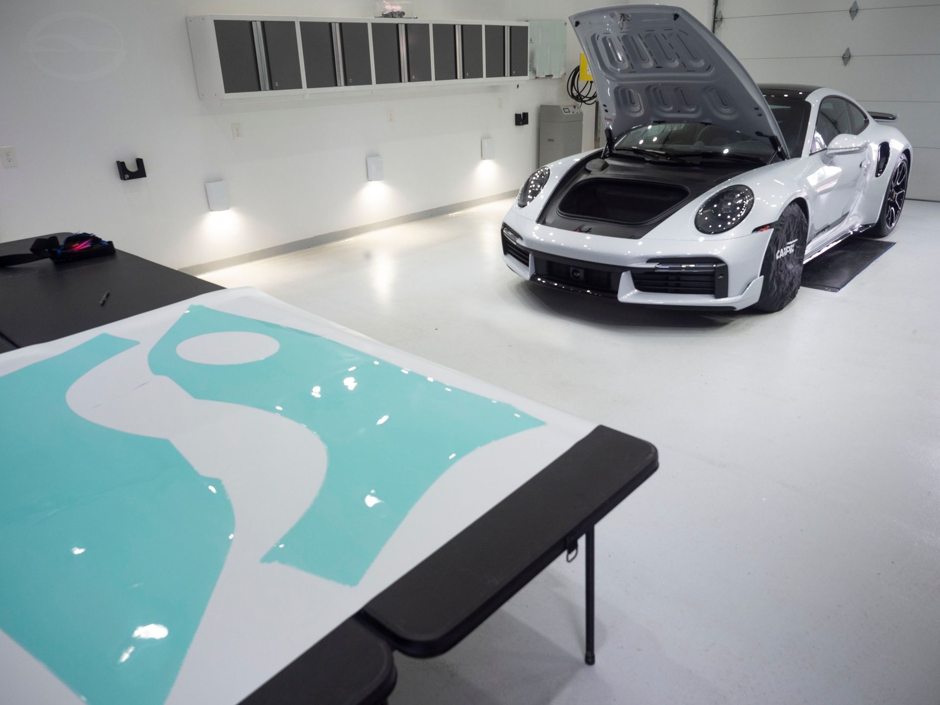 A silver porsche 911 turbo s is parked on the side of the road.