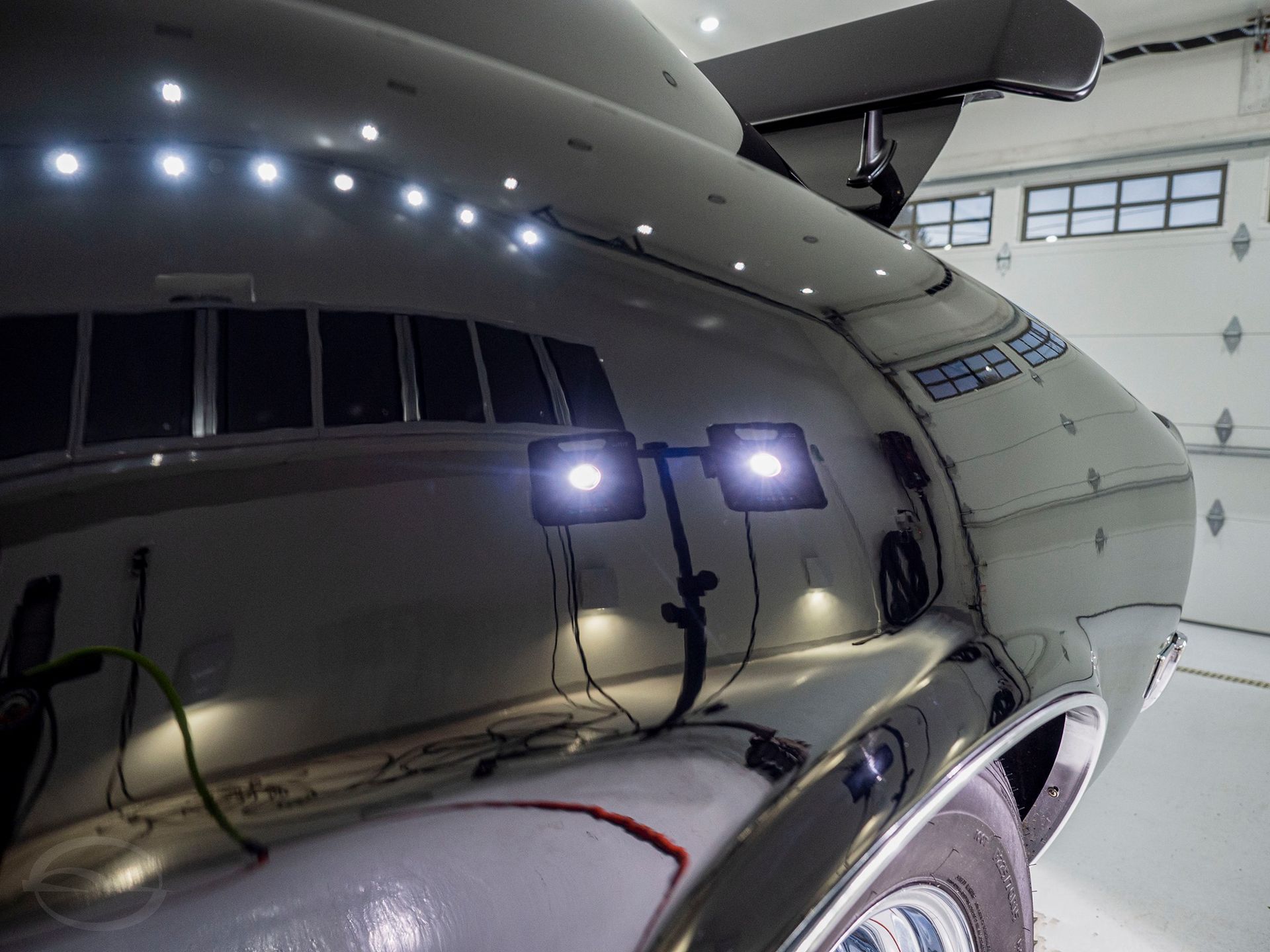 A car is sitting in a garage with lights on it