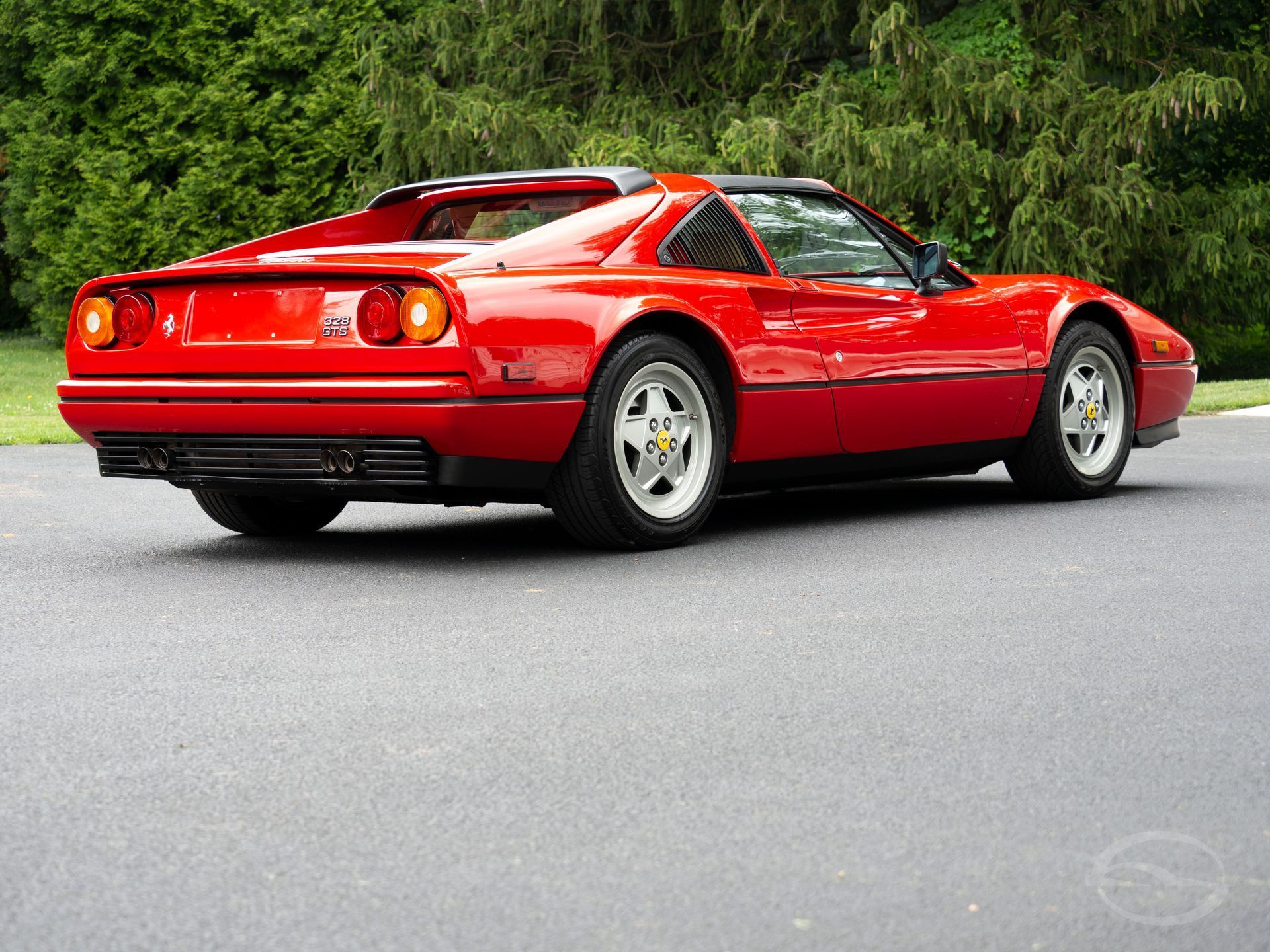 A silver porsche 911 is parked on the side of the road.