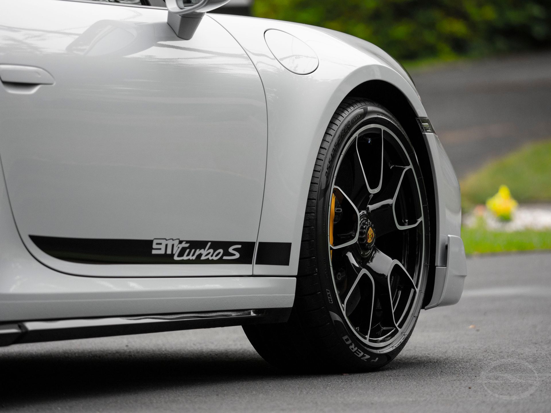 A white porsche turbo s is parked on the side of the road