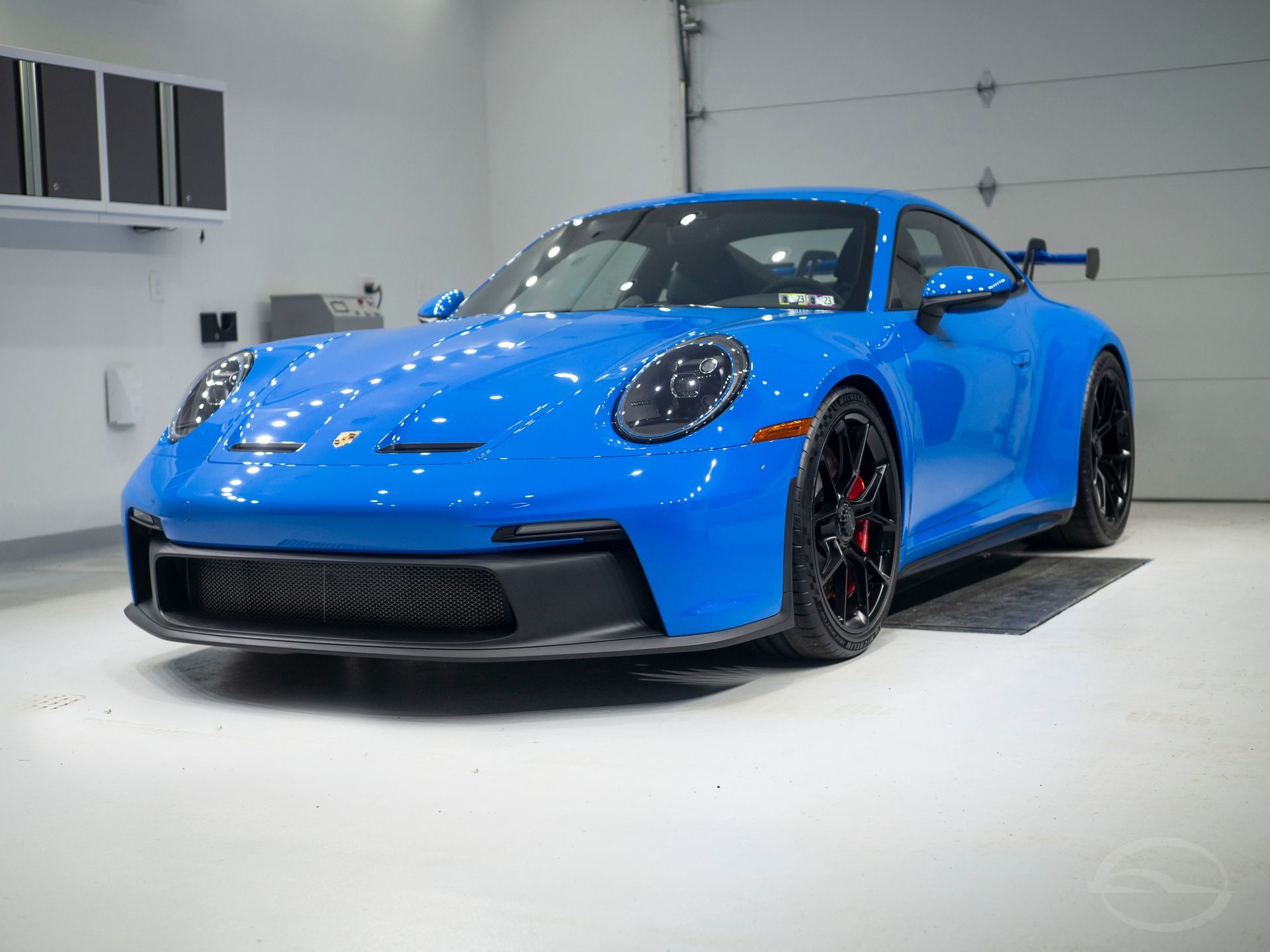 A blue porsche 911 gt3 is parked in a garage.