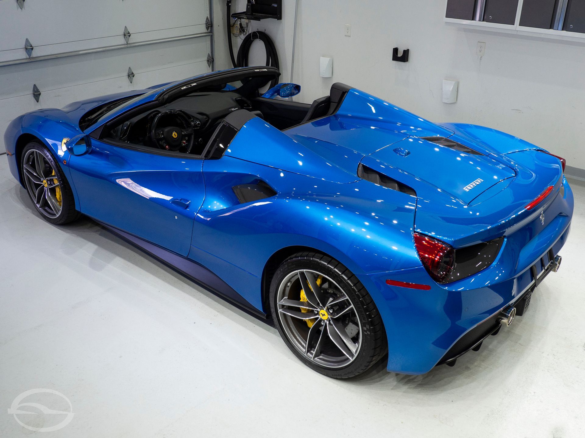 A blue sports car is parked in a garage.