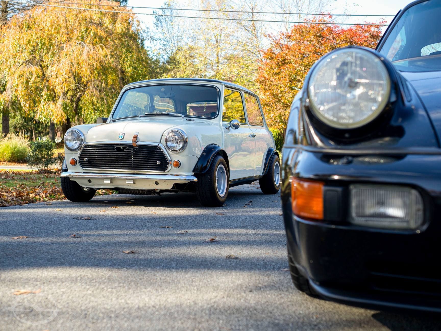 An orange car is parked in front of a garage door